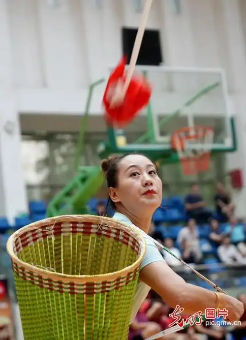 在广西柳州市融水苗族自治县体育公园,一名选手在抛绣球比赛中抛绣球