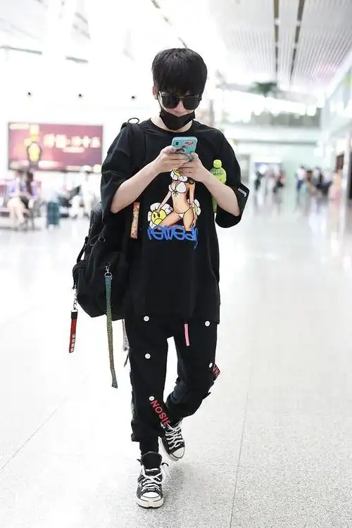 组图:大张伟独自背包赶飞机显低调 装扮嘻哈潮范儿十足