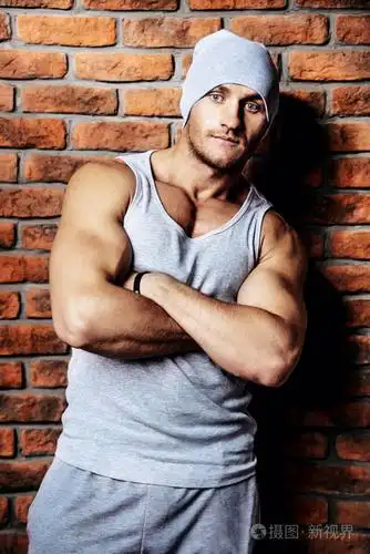 肌肉健壮的男人站由一堵墙.体育生活方式.健美