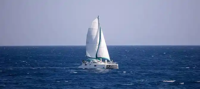 帆船在平静的大海中随风而行.人们享受帆船, 蓝天背景, 旗帜照片