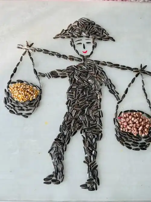 他家桌子上,一幅《五谷丰登》图非常生动,只见一个用瓜子拼就的小人头