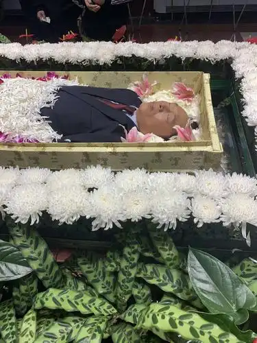 告别大厅正中央,黄雪林的遗体安卧在鲜花丛中,遗容坚毅安详.