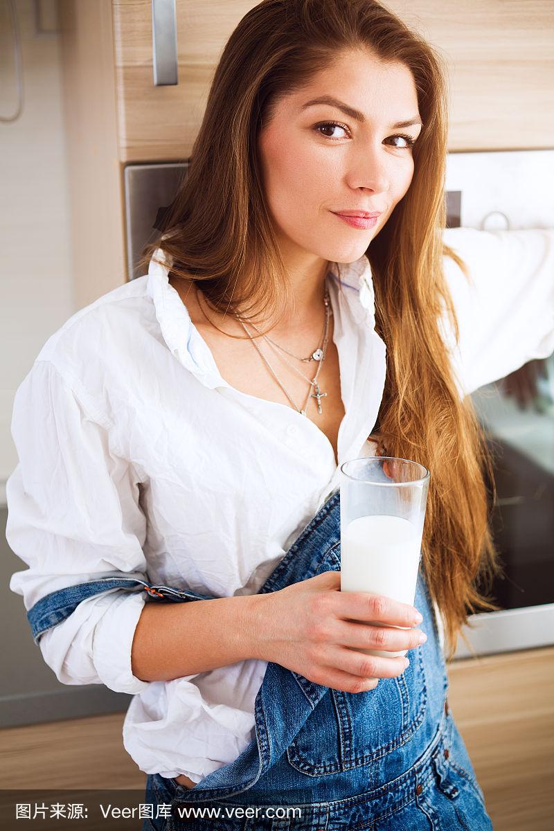 一个年轻漂亮的女人,手里拿着一杯牛奶