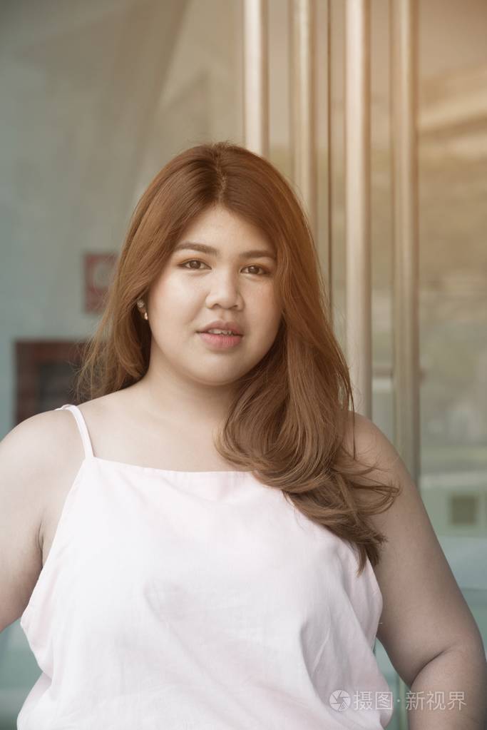 亚洲漂亮笑脸的画像胖女人摆在建筑的幸福前面照片-正版商用图片09h0