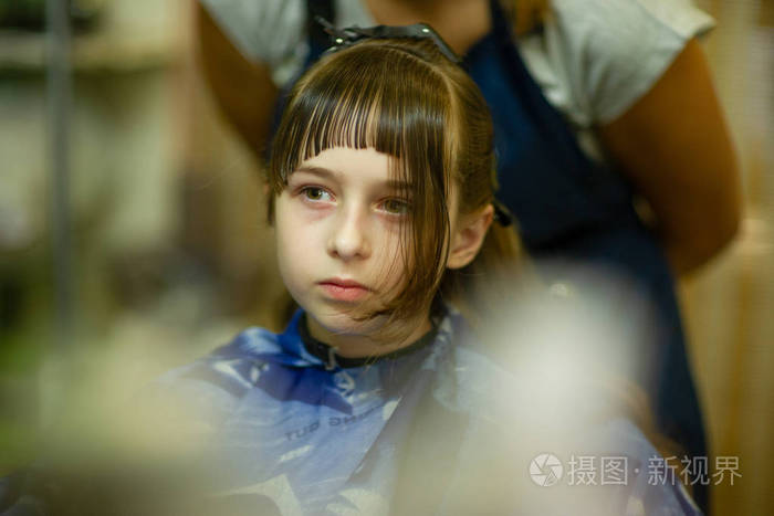 理发师给可爱的小女孩做发型