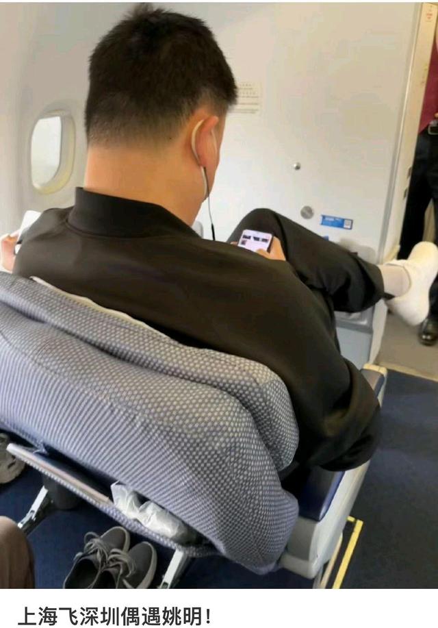 姚明坐飞机出行被偶遇!体型巨大伸不开腿,穿着朴素,全程玩手机