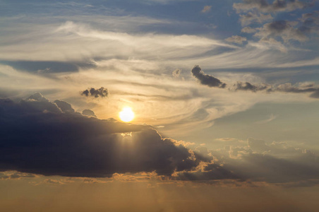在晴朗的天空上,由明亮的橙色黄色太阳照亮的深蓝色云彩的美丽景色.