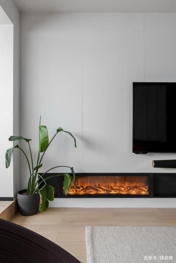 传统的电视柜作为收纳,而是选用了一个嵌入式的设计,加装了一个小壁炉
