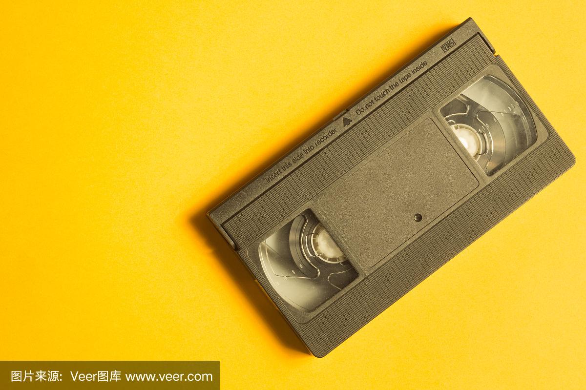 录像带隔离在黄色背景上.带拷贝空间的磁带