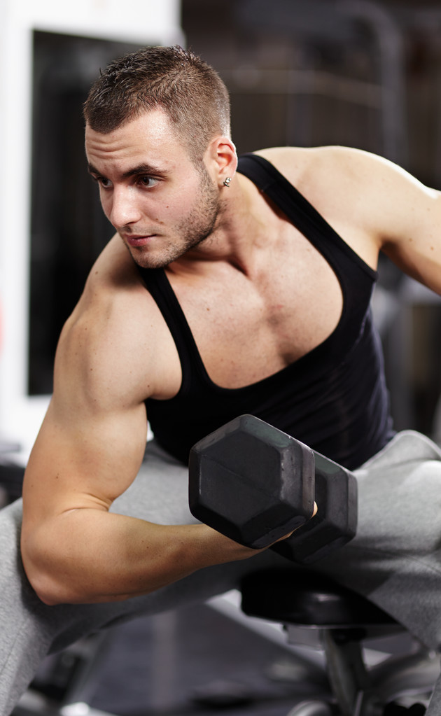 健壮的男人工作与重哑铃