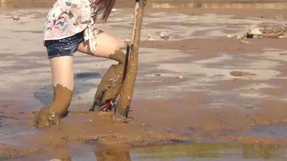 美女穿红色雨靴泥河里摸鱼拔不出腿