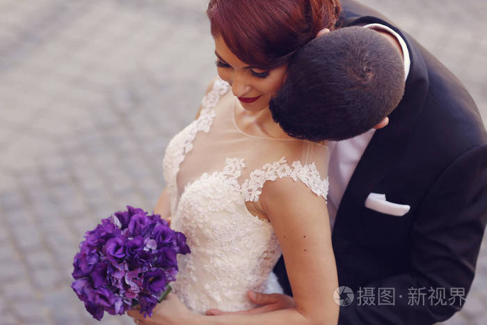 新郎的脖子亲吻他的新娘照片-正版商用图片0oupo5-摄图新视界