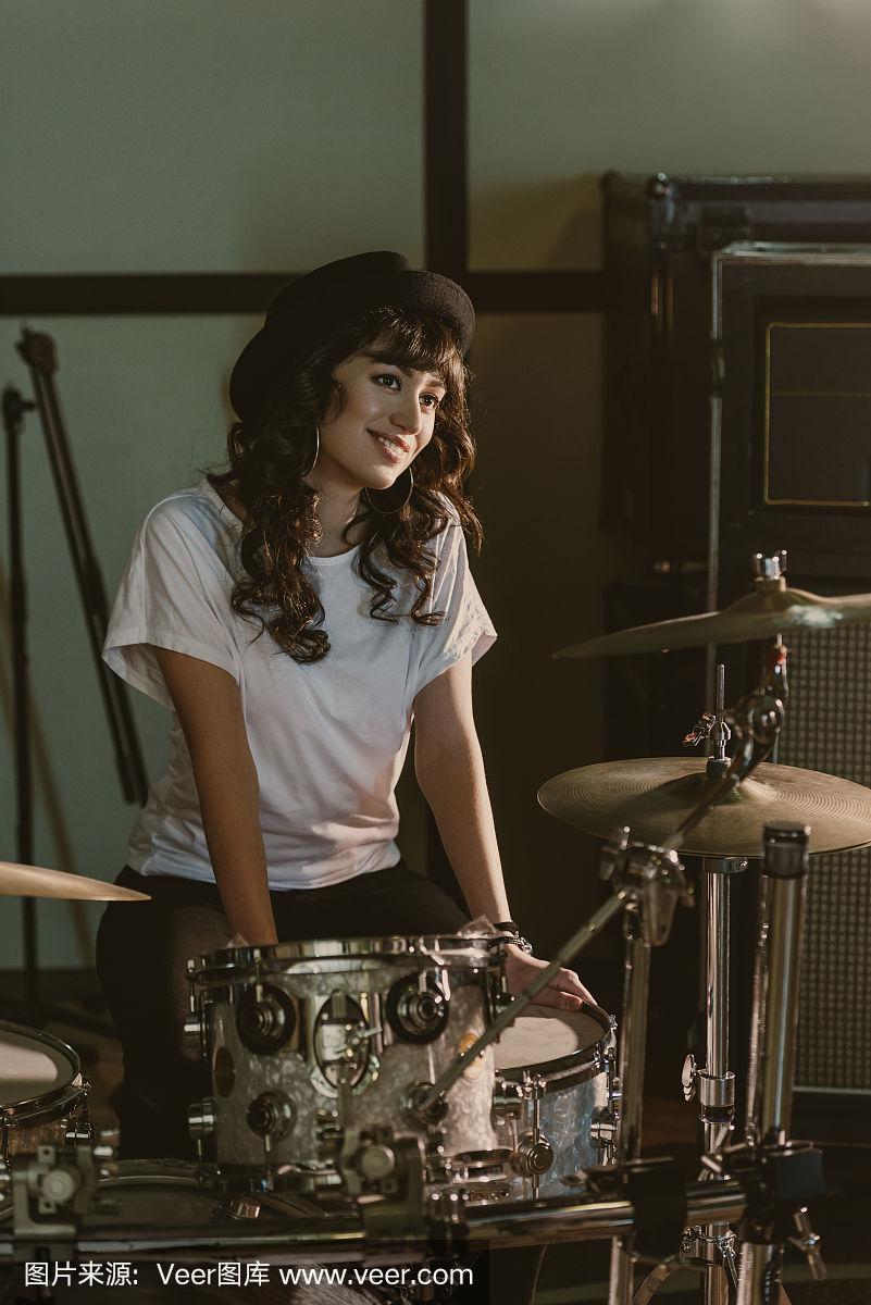 迷人的女鼓手坐在架子鼓