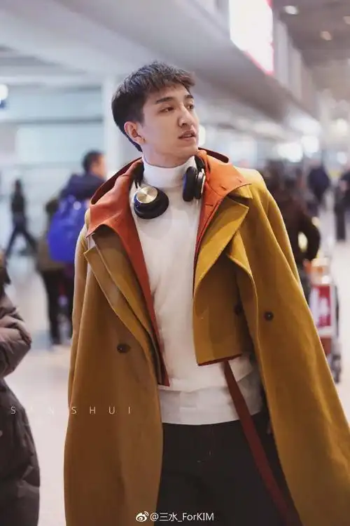 金瀚穿黄色长款大衣搭配白色高领毛衣现身机场,笑容灿烂帅气十足