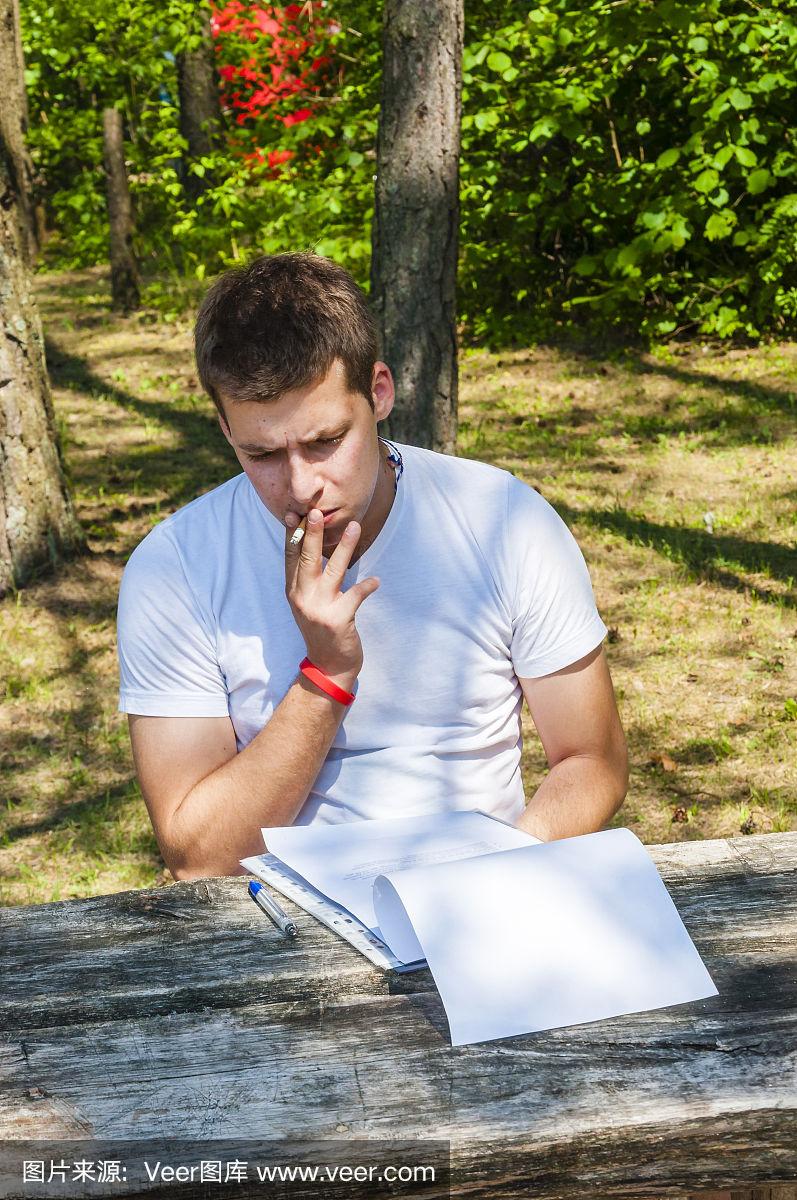 年轻人坐在户外,抽烟,思考着印刷文本