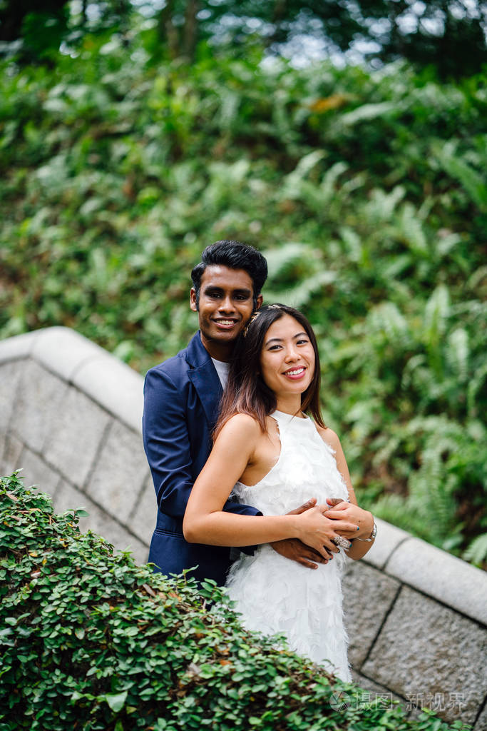 在亚洲, 一个有吸引力的情侣在公园里站在一起.他们正在拍婚礼照片.