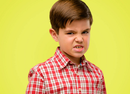 的眼睛愤怒和压力皱眉脸不满, 恼火和恼火, 表示愤怒的黄色背景照片