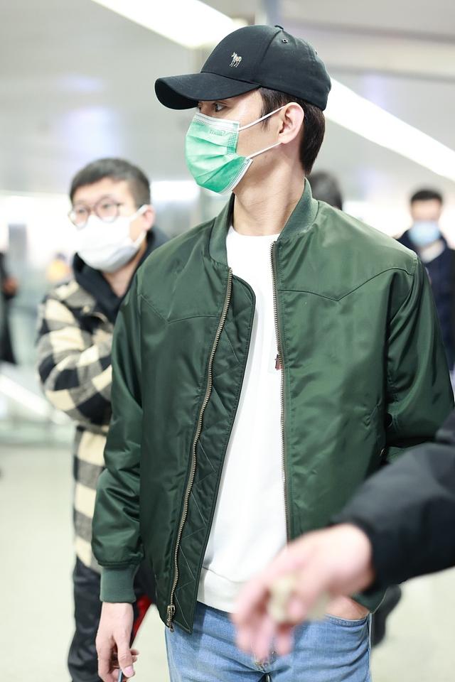 组图:王凯穿绿色飞行夹克现身机场 赶路不时低头看手机