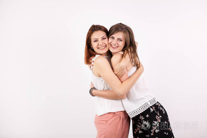 两个美丽的女孩朋友拥抱对方