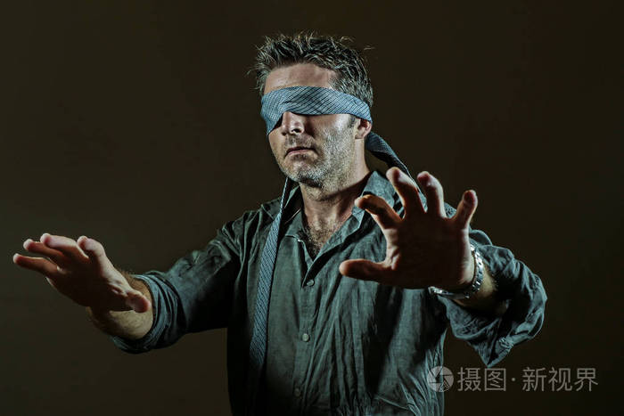 年轻的迷失和困惑的男人被蒙着脖子玩网络潮流危险的挑战,眼睛失明