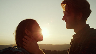 深情的男人看着女人的眼睛站在山顶上的情侣