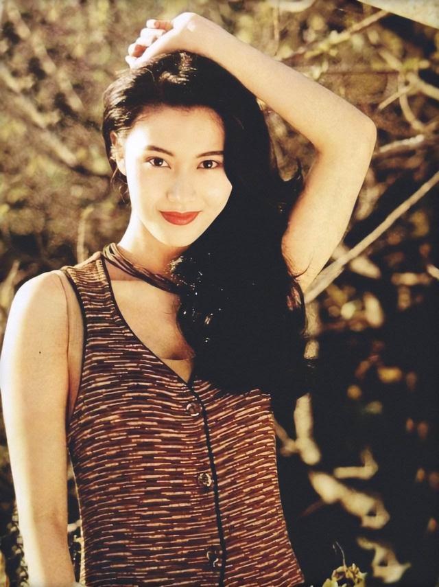 年轻时的李嘉欣美丽大方,身着紫色吊带长裙,温柔浪漫