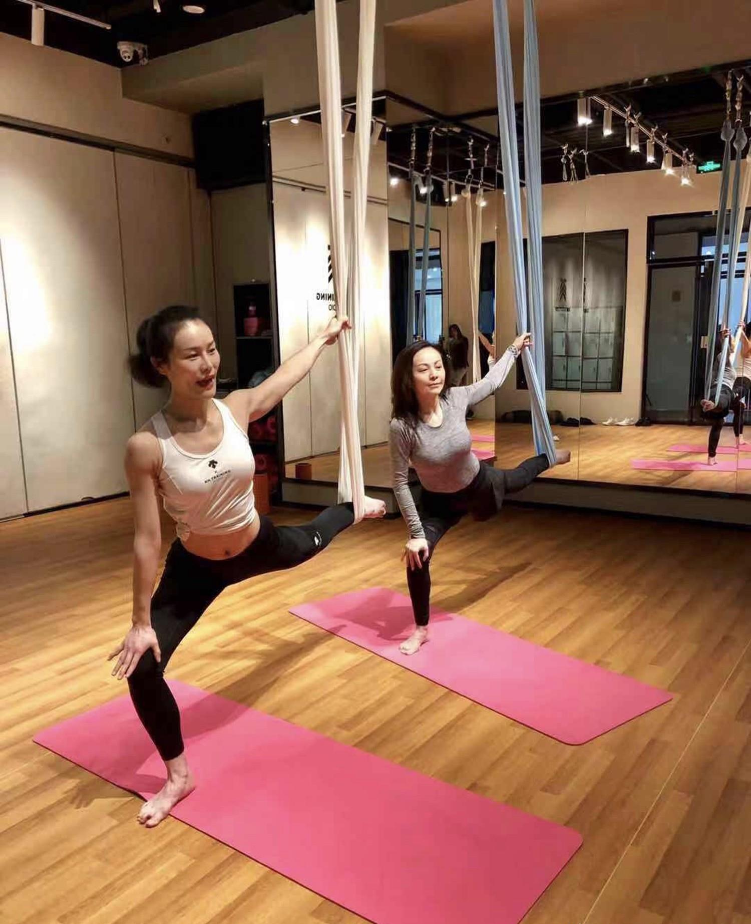 照片一中的王琳,在一条瑜伽吊绳上摆着标准的姿势,满脸笑容,貌似是很