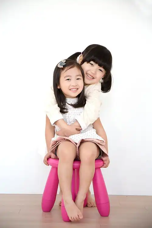 两个小女孩微笑着拥抱着图片