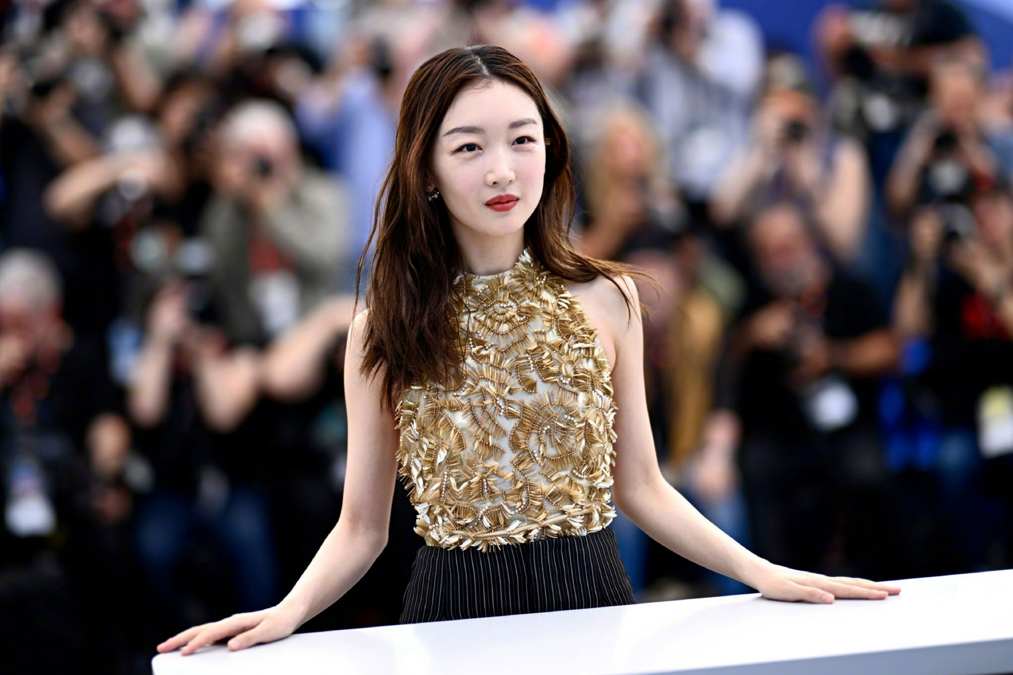 周冬雨亮相戛纳电影节新片《燃冬》媒体photocall环节,金色露背上衣配