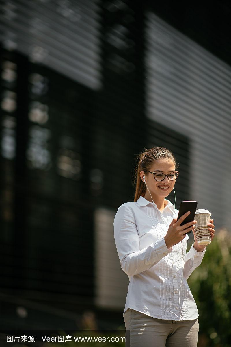 年轻的女商人在户外发短信