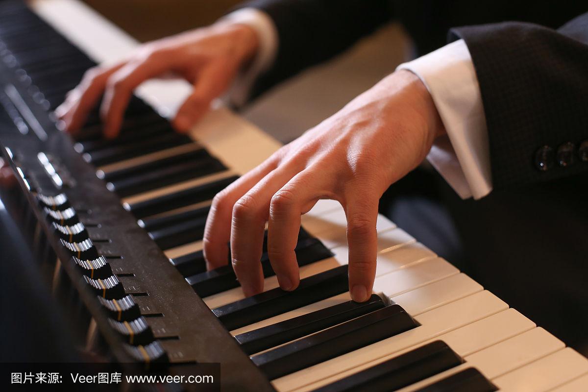 钢琴家弹钢琴.黑色背景上的钢琴键