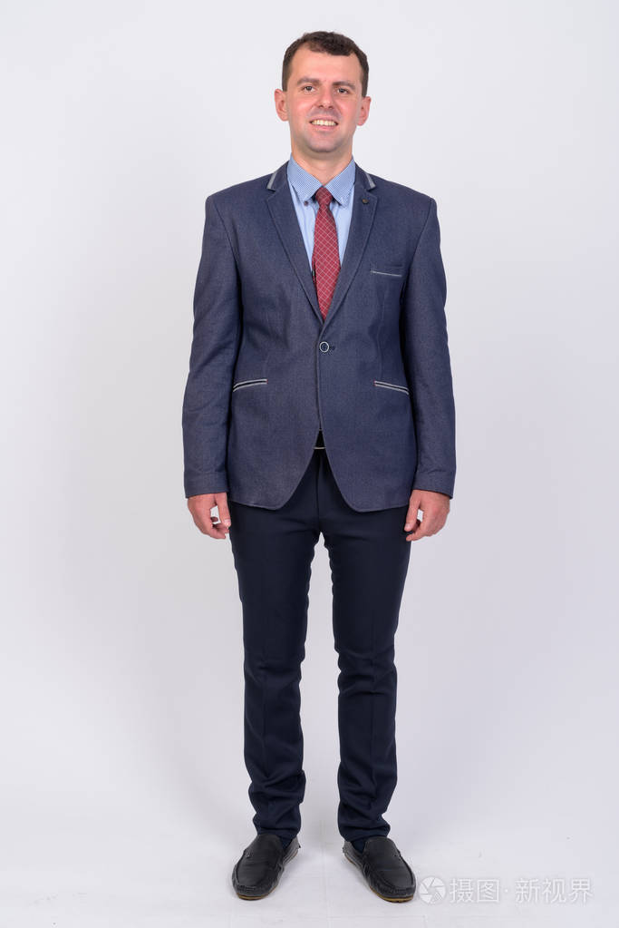 全身拍摄的快乐商人在西装微笑