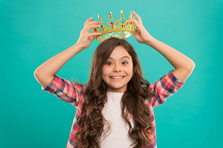 女孩可爱的婴儿戴皇冠, 而站蓝色背景.成为公主的概念.