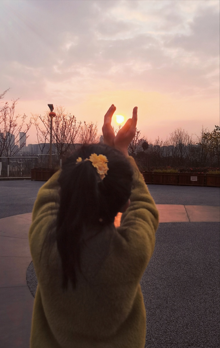 小女孩托起太阳背影黄昏日出