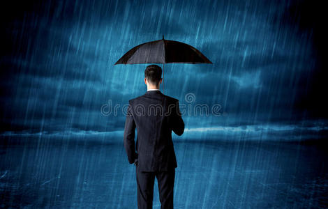 雨中撑伞的商人照片