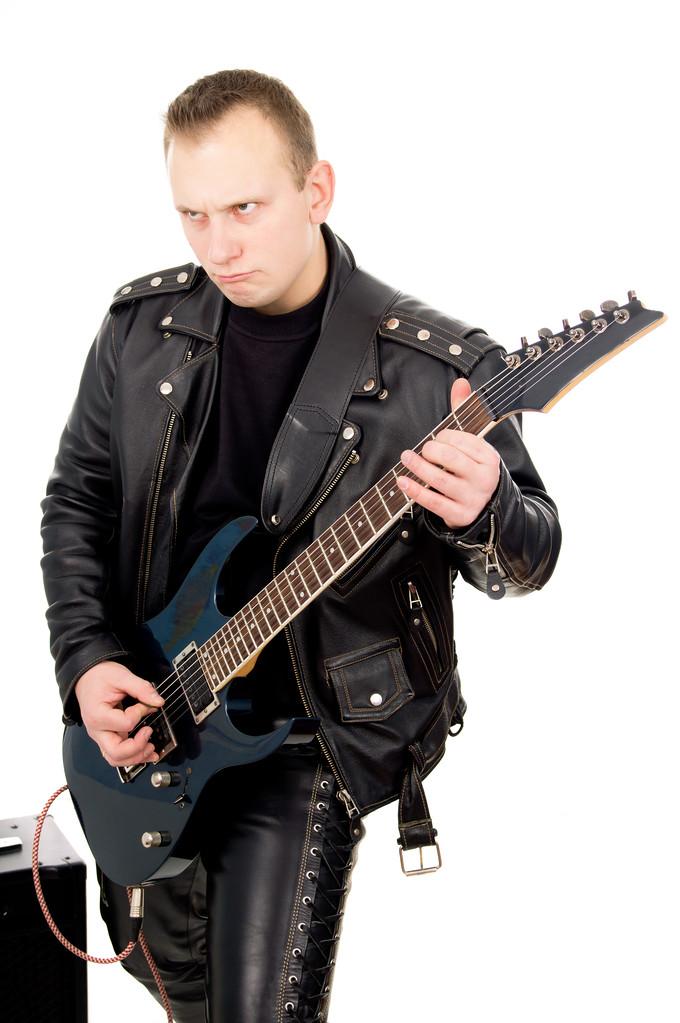 摇滚吉他手在皮革服装,与声音放大设备