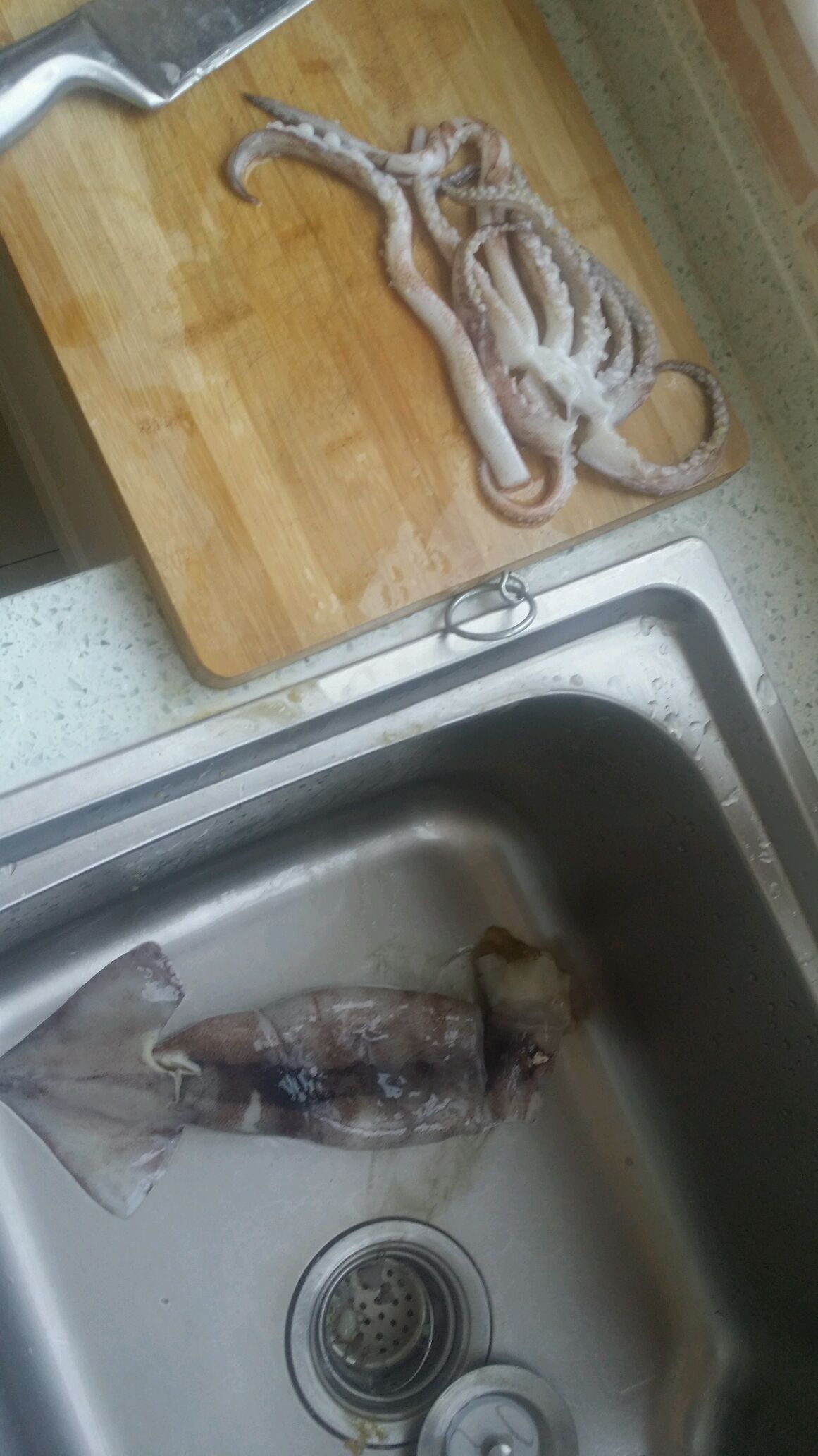 把鱿鱼须从头部分离下来.分解完毕,去黑膜!