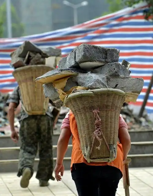 沉重的背篓压弯夫妻俩的腰.