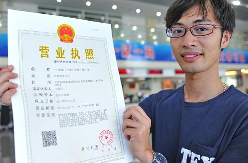 58,陈以麒展示刚办好的"一照一码"的统一社会信用代码的营业执照