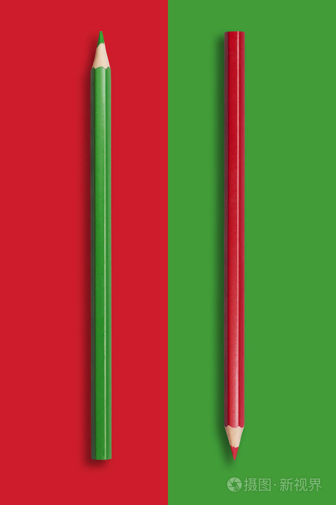 红色和绿色背景的两支绿色和红色铅笔symb