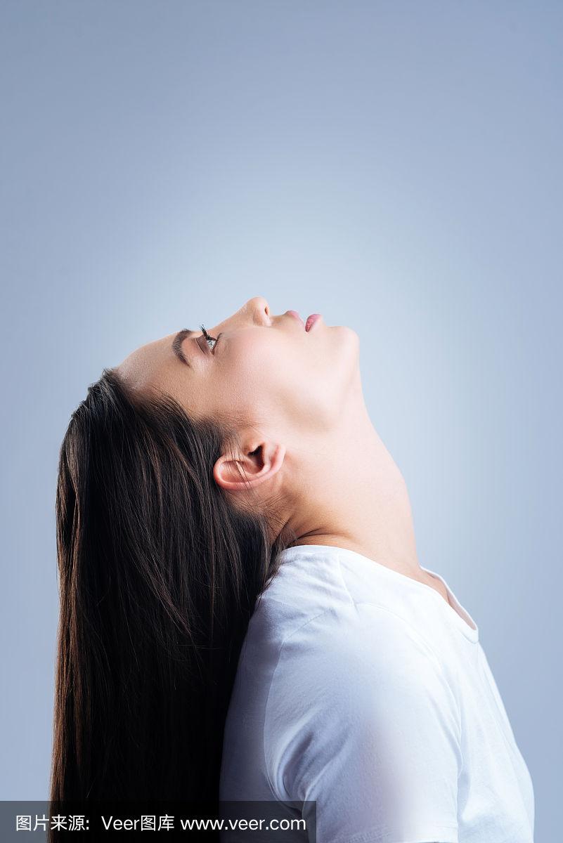 负责任的女人在滴鼻药水时头向后仰