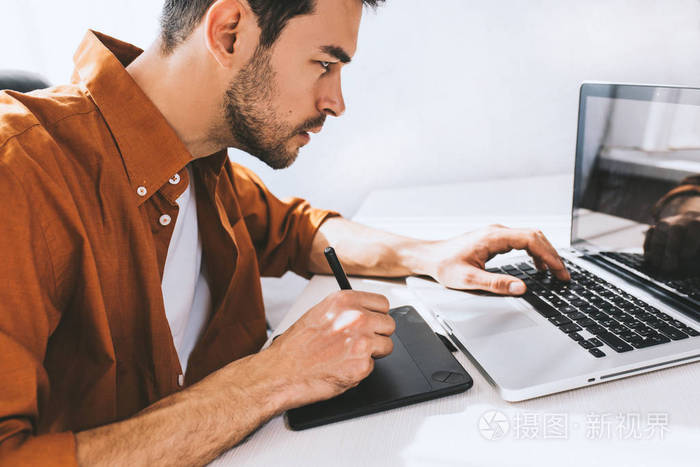 集中的男性自由职业者坐在笔记本电脑前认真和周到的表达.