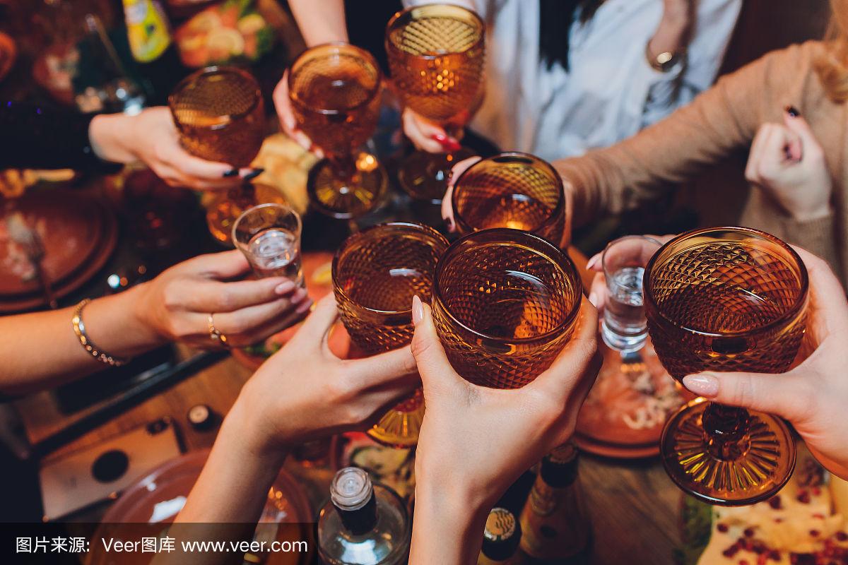 近距离拍摄的一群人与葡萄酒或香槟碰杯前的散景背景.年长的人手中.