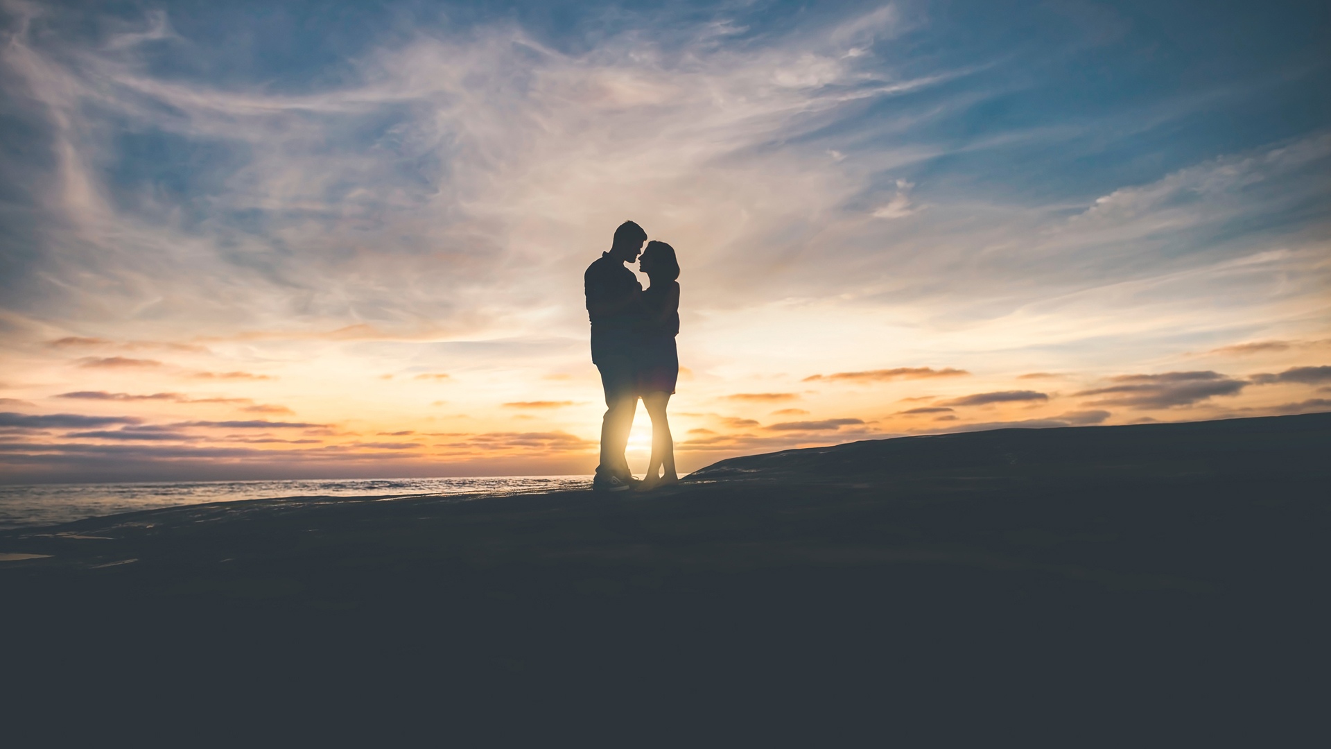 夕阳下的情侣拥抱亲吻