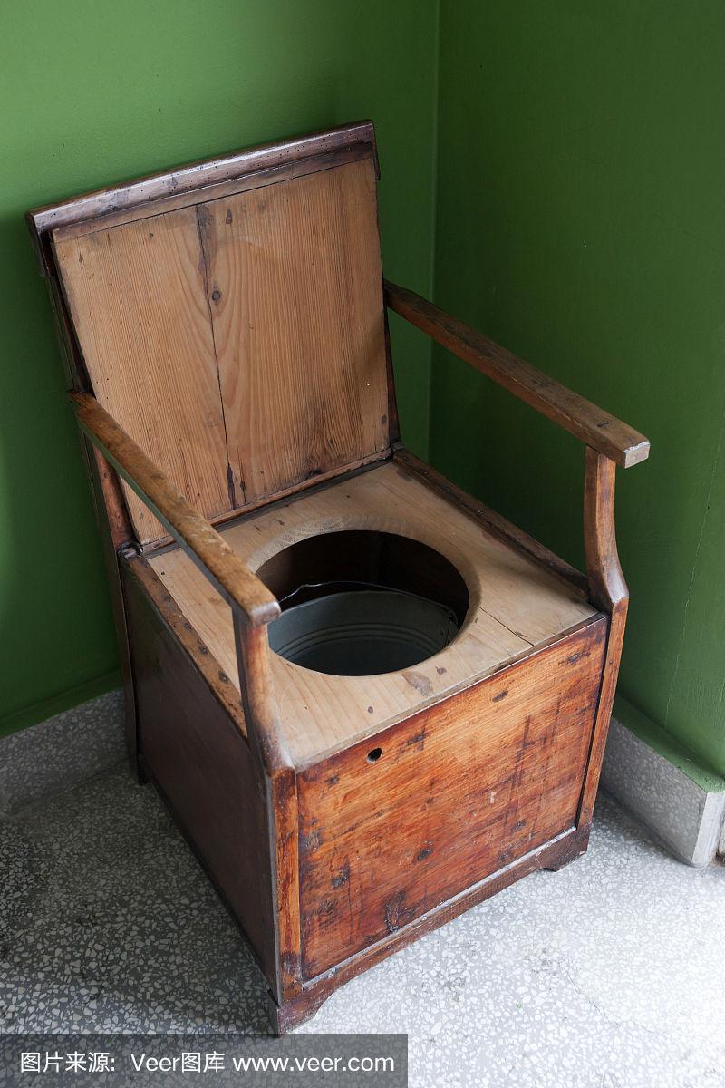 木制扶手椅和水桶制成的老式马桶